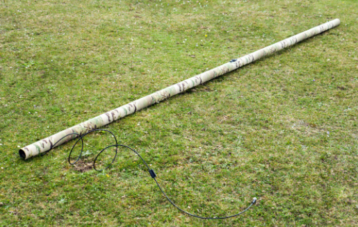 IAM mast unrolled flat on grass with cable extended